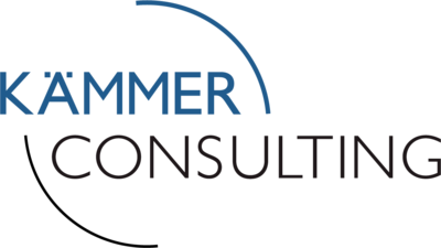 Ein Logo, das den Text „KÄMMER CONSULTING“ in Großbuchstaben zeigt. Das Wort „KÄMMER“ ist in blauer Schrift gehalten, während „CONSULTING“ in schwarzer Schrift erscheint. Zwei gebogene Linien umrahmen die Worte teilweise, eine oben in Blau und eine unten in Schwarz.